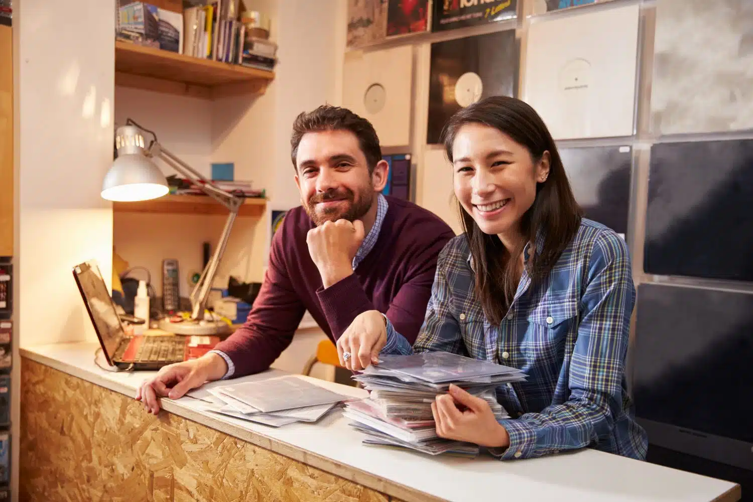 Smiling business partners behind the counter of a vinyl and music store