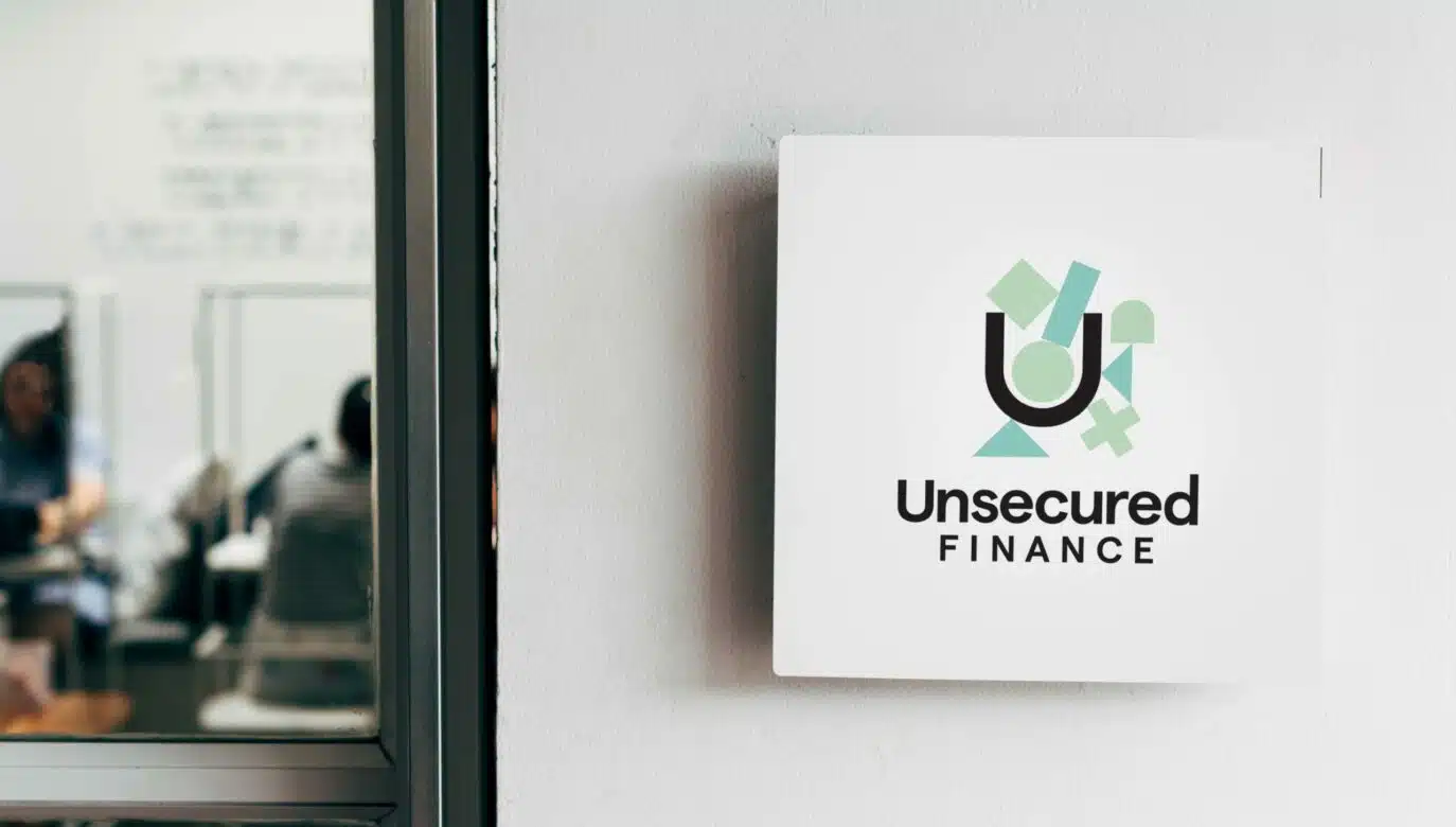 Unsecured Finance logo displayed on a signboard outside a modern office